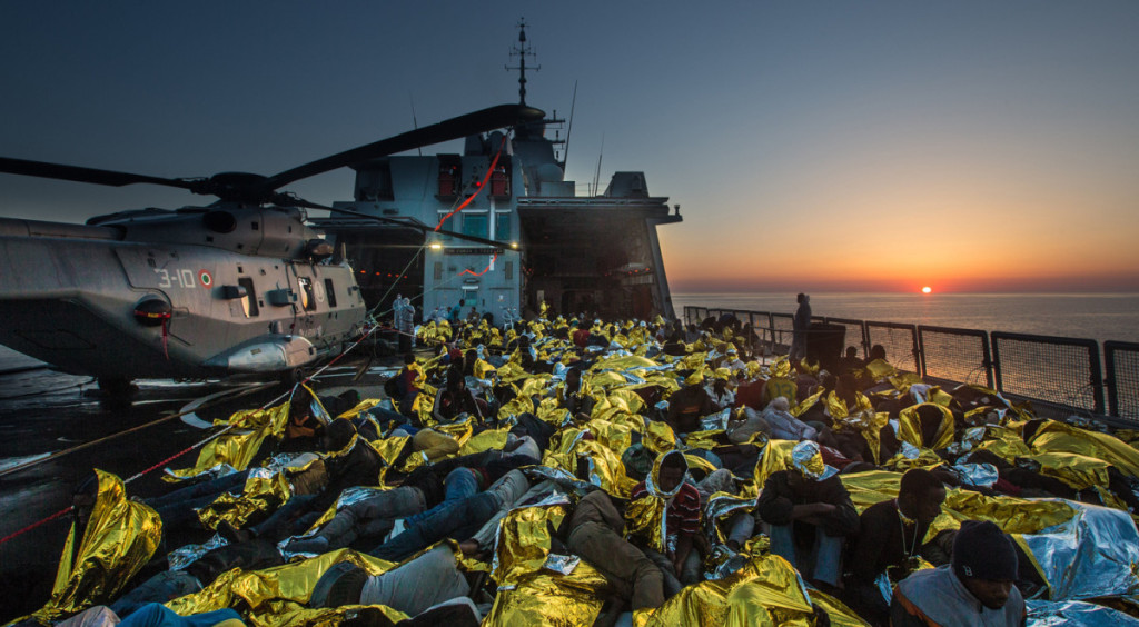 June 8, 2014 - Mediterranean Sea / Italy: African asylum seekers rescued off boats and taken aboard an Italy navy ship. More than 2,000 migrants jammed in 25 boats arrived in Italy June 12, ending an international operation to rescue asylum seekers traveling from Libya. They were taken to three Italian ports and likely to be transferred to refugee centers inland. Hundreds of women and dozens of babies, were rescued by the frigate FREMM Bergamini as part of the Italian navy's "Mare Nostrum" operation, launched last year after two boats sank and more than 400 drowned. Favorable weather is encouraging thousands of migrants from Syria, Eritrea and other sub-Saharan countries to arrive on the Italian coast in the coming days. Cost of passage is in the 2,500 Euros range for Africans and 3,500 for Middle Easterners, per person. Over 50,000 migrants have landed Italy in 2014. Many thousands are in Libya waiting to make the crossing. (Massimo Sestini/Polaris)